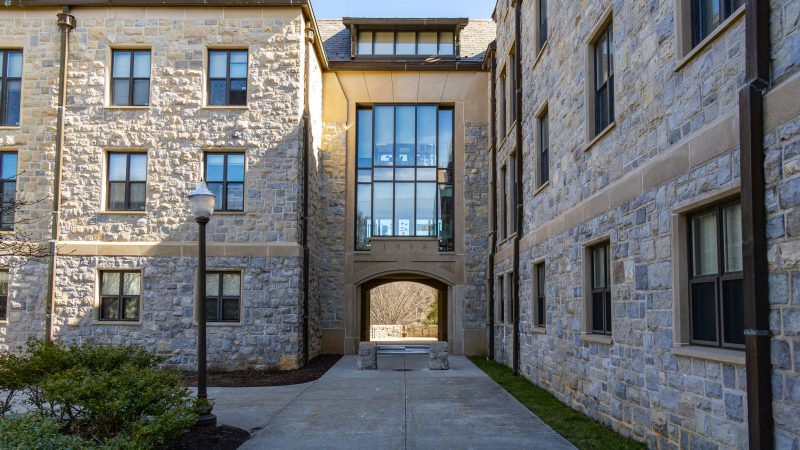 A view of the central archway of New Residence Hall East with both wings stretching out away from the central archway.