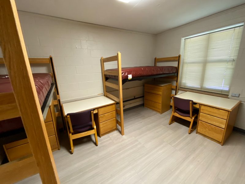 The inside of a traditional-style room in Vawter Hall, with two lofted beds, desks, and chairs.