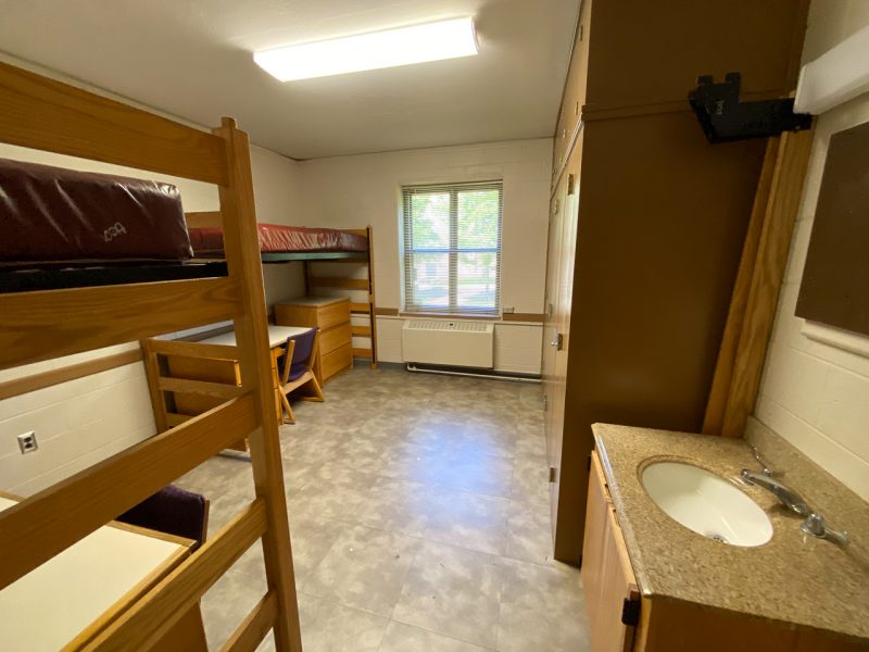 The inside of a traditional-style room in Whitehurst Hall, with two lofted beds, desks, and chairs.